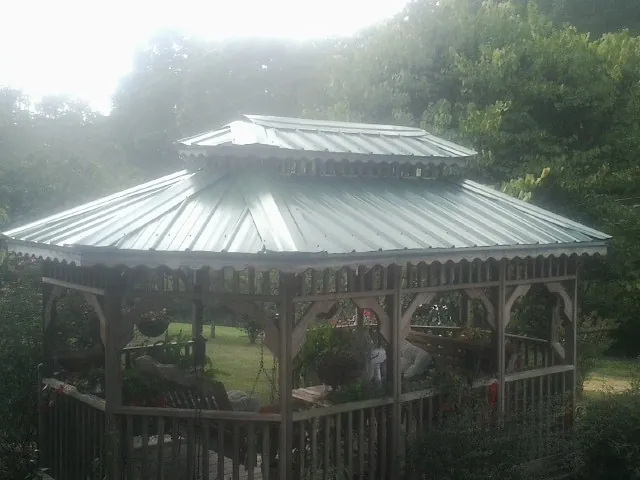 Two tier green metal roof on a garden gazebo in Hustle